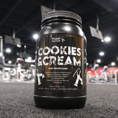 A Cookies & Cream whey protein canister up close with the blurred-out background of a gym.